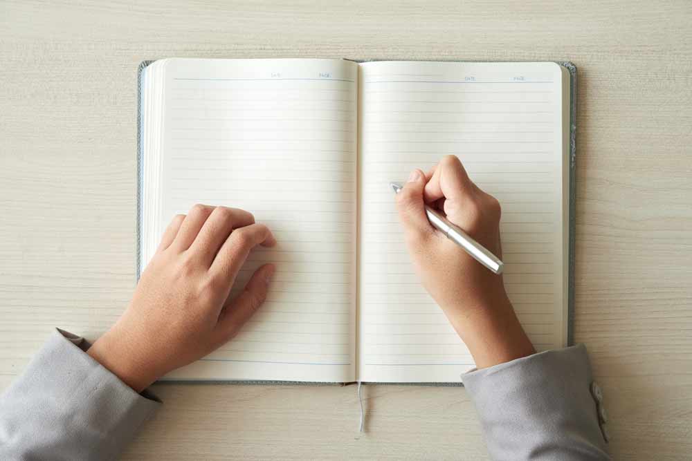 Top view of hands ready to fill in the diary.