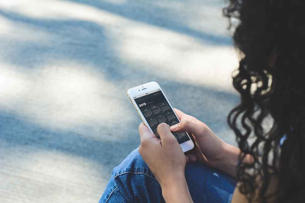 Woman holding smartphone with diary app.