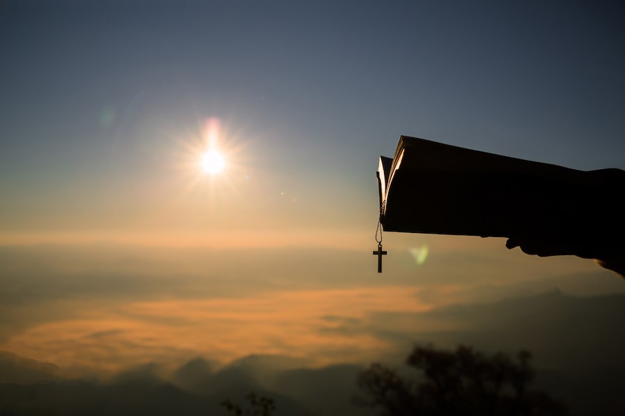 A man reading a holy bible on a mountain top.