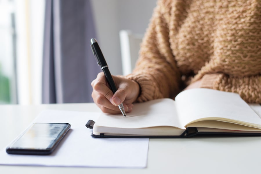 A close up of a lady making notes.