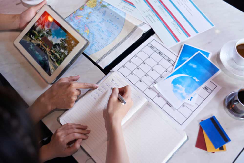 Top view of people writing a travel journal before and after a vacation trip.